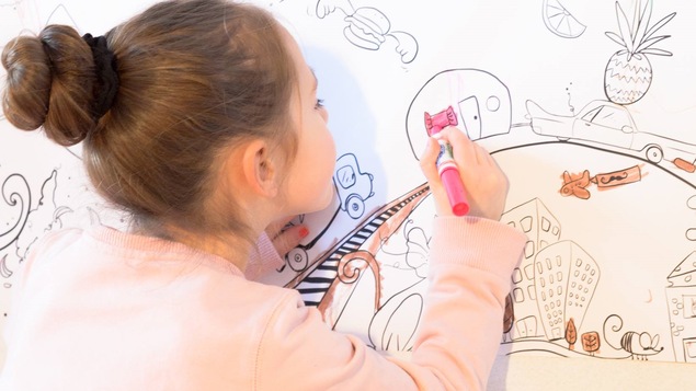 Petite fille qui dessine sur un tableau