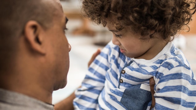 Un père est en train de consoler son fils.