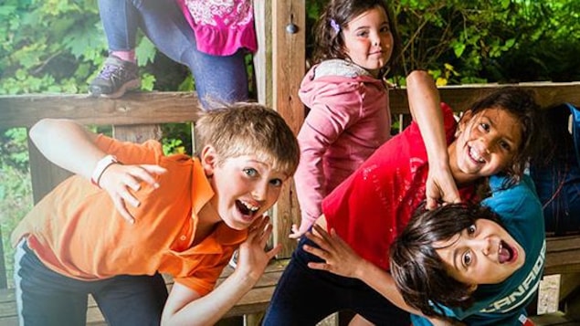 Des enfants se penchent dans tous les sens en riant.