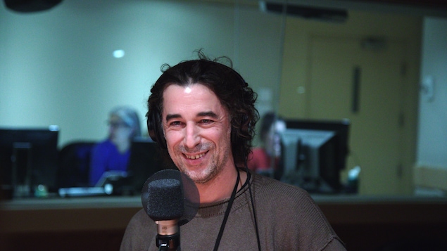 Erwan Larher, avec des écouteurs sur la tête, assis derrière un micro.