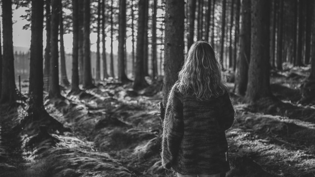 Une jeune femme marche seule dans la forêt. Pour certains, cette image a un effet apaisant. Pour d'autres, un effet angoissant.