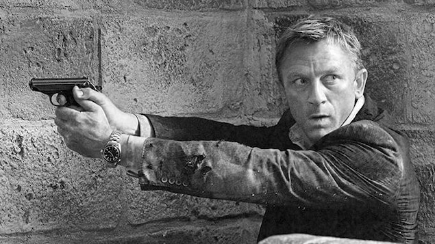 L'acteur Daniel Craig dans le rôle de James Bond brandit un Walther PPK.