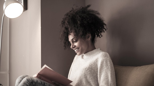 Une jeune femme lit un livre.