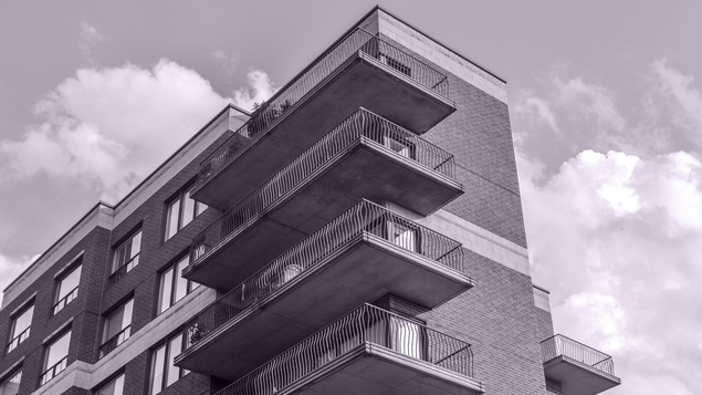 Une image en noir et blanc d'un bloc d'habitations.