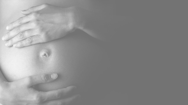 Un gros plan sur le ventre d'une femme enceinte.