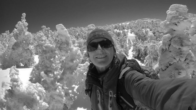 L'alpiniste Nathalie Fortin prend un égoportrait, sur le sommet d'une montagne enneigée.