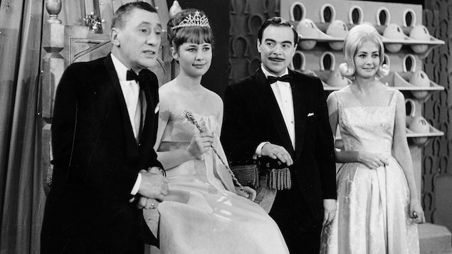 L'animateur Roger Baulu prend la pose avec Marie-Claude Lévesque qu'on voit assise sur un trône coiffée d'un diadème, l'annonceur Henri Bergeron et l'hôtesse Lucie Gauthier.