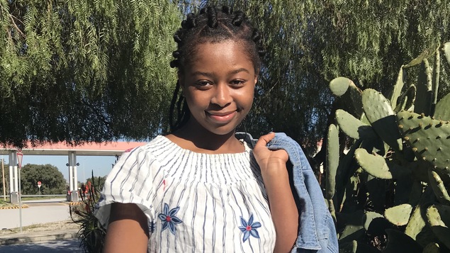 La jeune fille dans un jardin avec des cactus