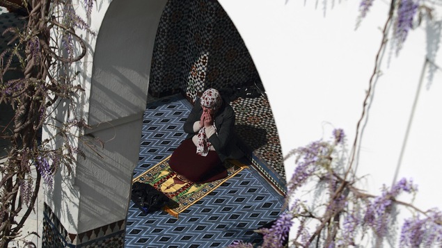 Une femme prie à la mosquée de Paris, sur un tapis.
