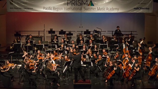 Un orchestre de jeunes musiciens en performance sur scène.