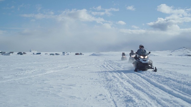 Des motoneigistes circulent sur la Route blanche près d'un village de la Basse-Côte-Nord.