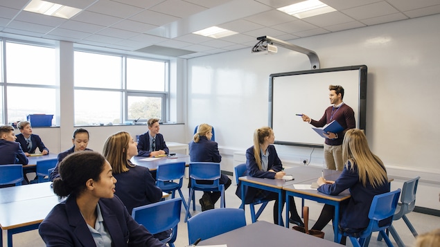 Un professeur enseigne à une classe de jeunes à l'école secondaire privé.