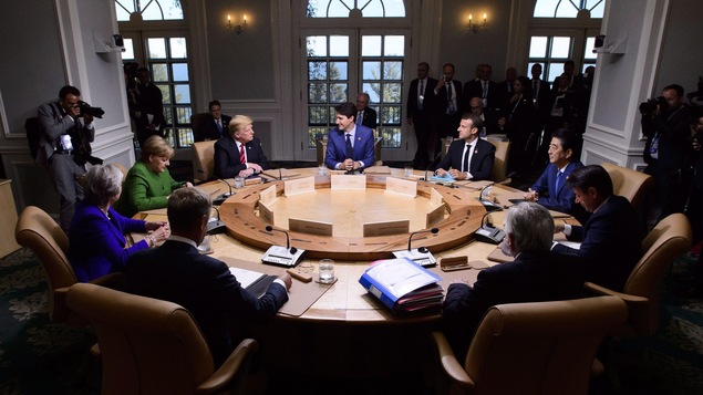 Une session de travail au G7 avec (dans le sens d'un horloge) Justin Trudeau, Emmanuel Macron(France), Shinzo Abe(Japon), Guiseppe Conte(Italie), Jean-Claude Junker(Commission Européenne), Donald Tusk(Conseil Européen), Theresa May(Grande-Bretagne), Agela Merkel(Allemagne) et Donald Trump(États-Unis)