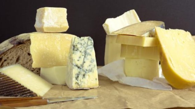 Différentes sortes de fromages avec un couteau et du pain.