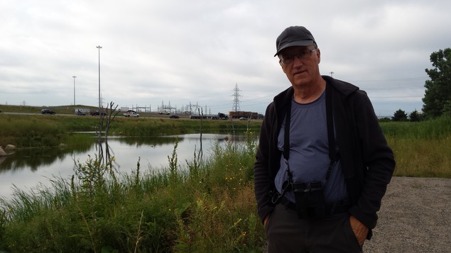 Photo d'un homme près d'un bassin de rétention