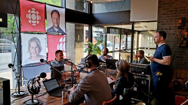 Six personnes assis autour d'une table pour avant de débuter la dernière émission de Grands Lacs café