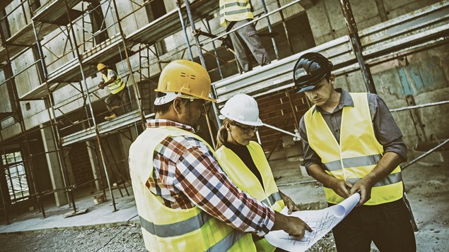 Une femme consulte un document sur un chantier de construction.