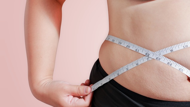Une femme mesure son tour de taille.