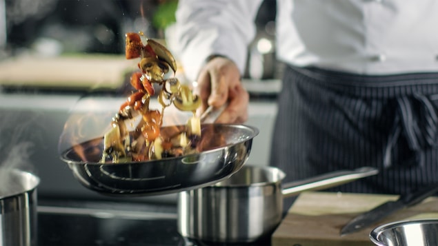 Un cuisinier à l'oeuvre dans la cuisine d'un restaurant.