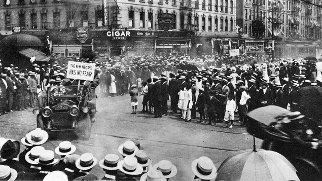 Une foule de plusieurs centaines de personnes réunies au coin d'une rue au début des années 1920.