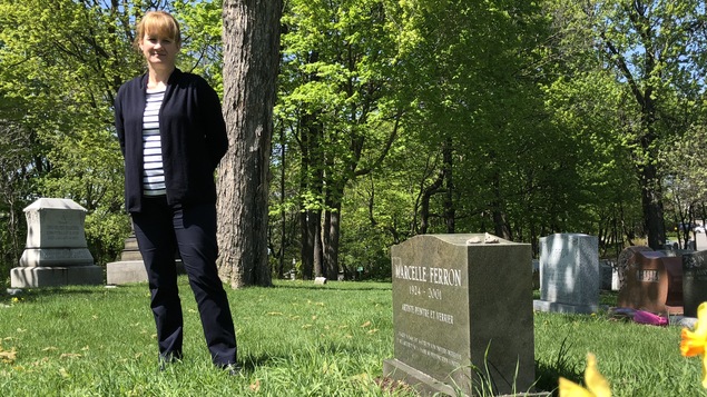 La directrice des programmes du patrimoine au Cimetière Mont-Royal de Montréal, Myriam Cloutier, devant la pierre tombale de la peintre Marcelle Ferron