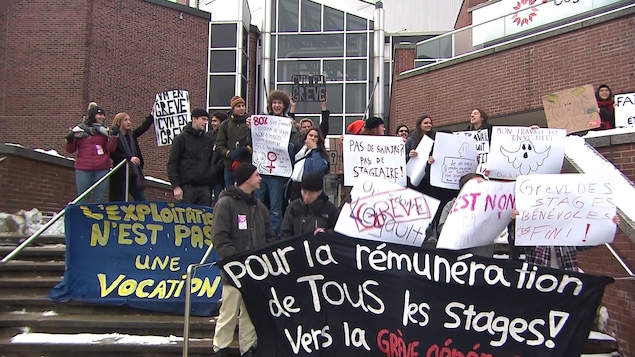 Des étudiants brandissent des affiches devant le Cégep du Vieux-Montréal.
