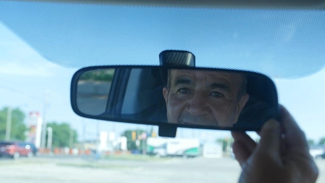 Le reflet d'un homme dans un miroir d'auto.