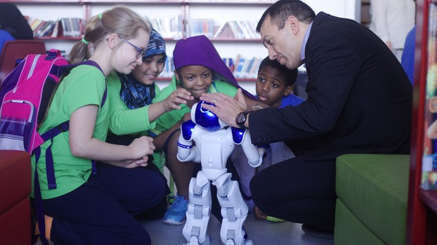 Thierry Karsenti avec un robot humanoïde et des élèves