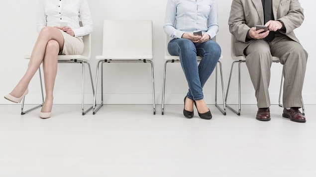 Trois personnes et une chaise vide.
