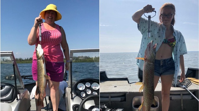 Deux femmes tiennent chacune un gros poisson qu'elles ont pêché.