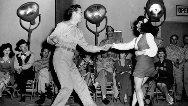 En 1944, un soldat américain et une jeune femme dansent sur de la musique swing.