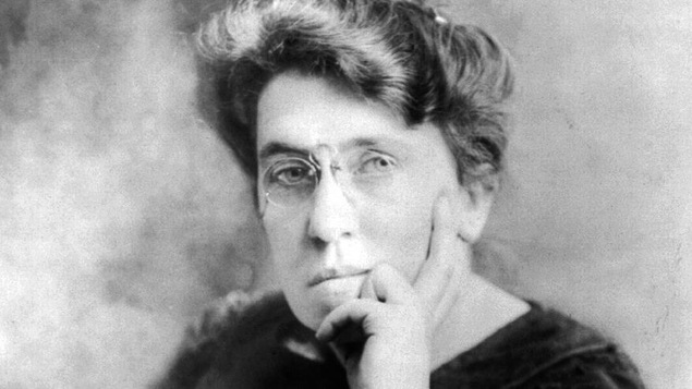 Photo en noir et blanc d'une femme avec des lunettes posant la main sur le visage.