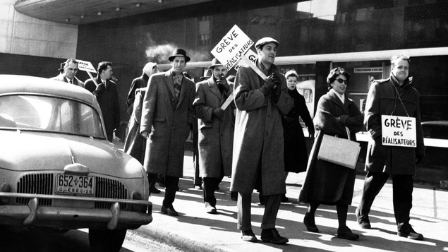 Des réalisateurs brandissent des pancartes devant l'édifice de Radio-Canada, en 1959.