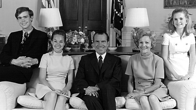 Portrait de famille formel en noir et blanc. La famille est assise au sofa dans une pièce de la Maison-Blanche.