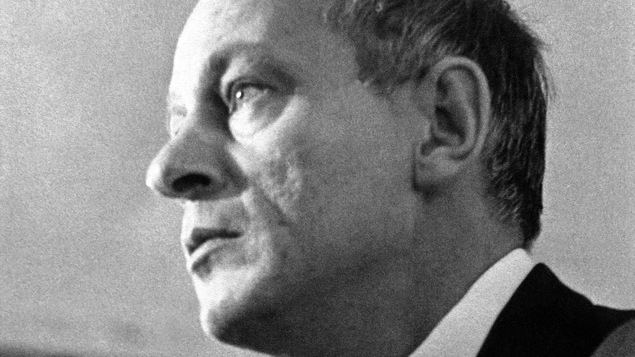 Photo en noir et blanc d'un homme de côté qui pointe le doigt vers l'avant.