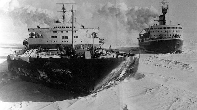 Photo en noir et blanc de deux navires naviguant dans la glace.