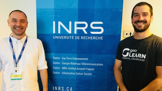 Deux hommes devant une affiche de l’INRS