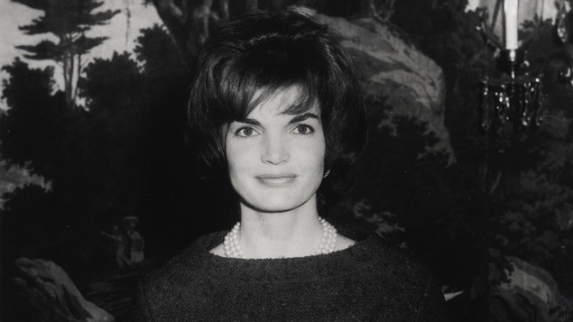 Jacqueline Bouvier Kennedy en 1961, souriant à la caméra (photo en noir et blanc)