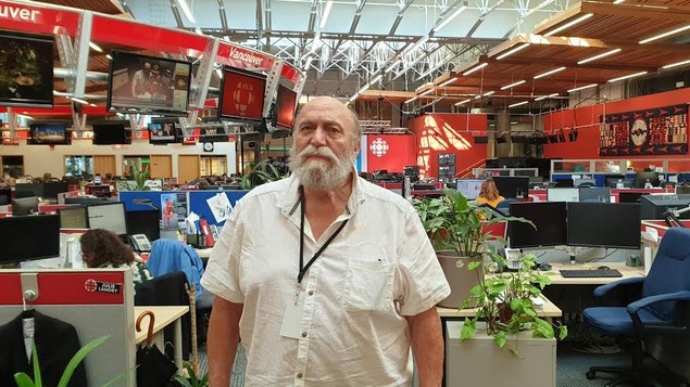 Un homme est photographié dans une salle de nouvelles.