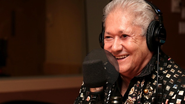 Jean-Paul Daoust souriant dans un studio de radio.