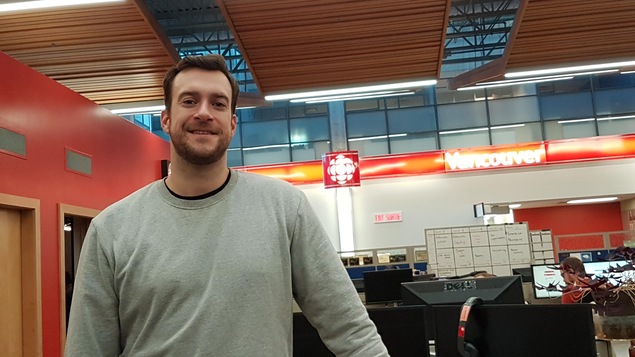 Un homme est est photographié plan taille dans une salle de nouvelles