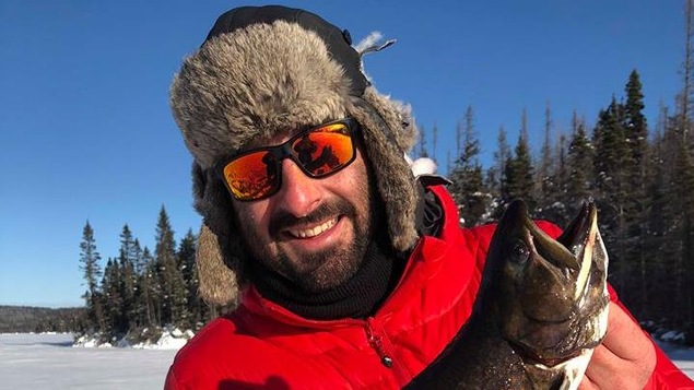 Le pêcheur Jessy Lalancette montre à la caméra l'une de ses belles prises de l'hiver.