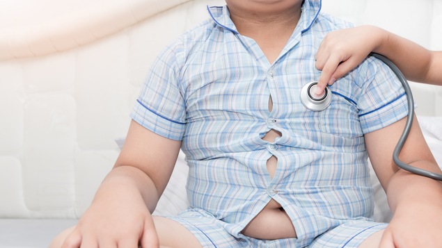 Un docteur avec un stéthoscope écoute le coeur d'un jeune garçon