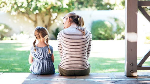 Une mère et sa fille sont assises et discutent calmement. 