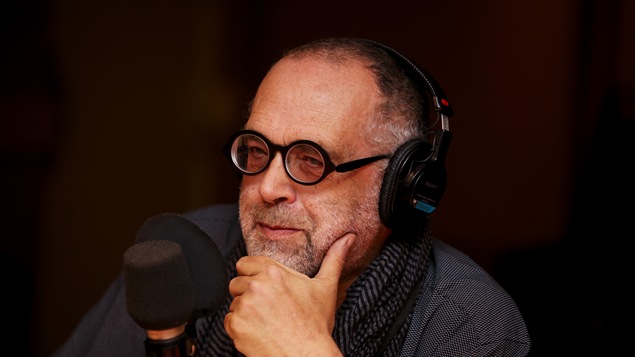 la main au coude, le professeur prend une pose sérieuse
