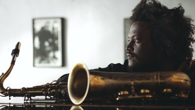 Plan épaule d'un homme noir avec son saxophone