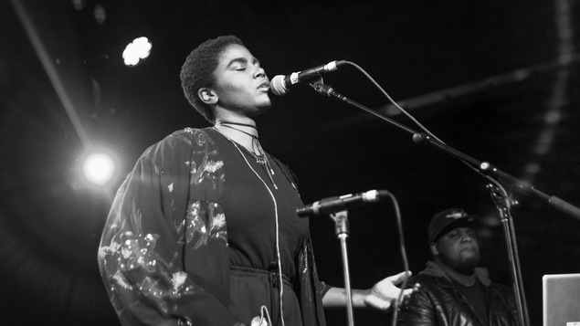 Karimah chante devant un microphone.