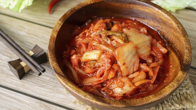 Un bol de kimchi avec des baguettes