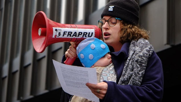 Une femme avec un bébé qui parle dans un porte-voix.