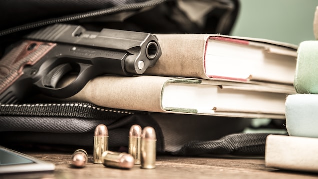 Un revolver dans un sac d'école qui contient des livres.